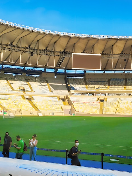 Maracanã Stadium field with visitors walking along the perimeter in Rio de Janeiro, Brazil.