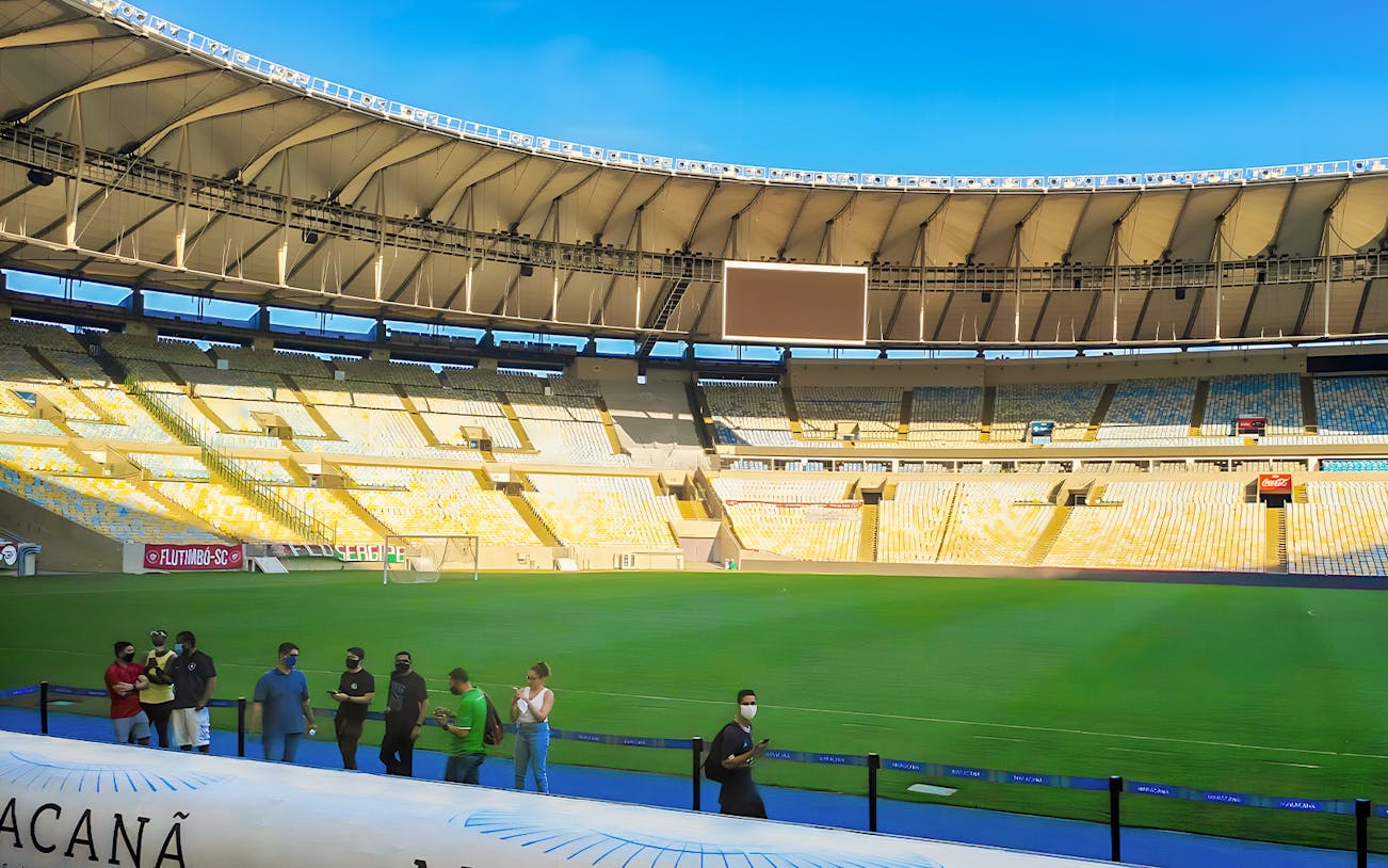 Maracanã Stadium field with visitors walking along the perimeter in Rio de Janeiro, Brazil.