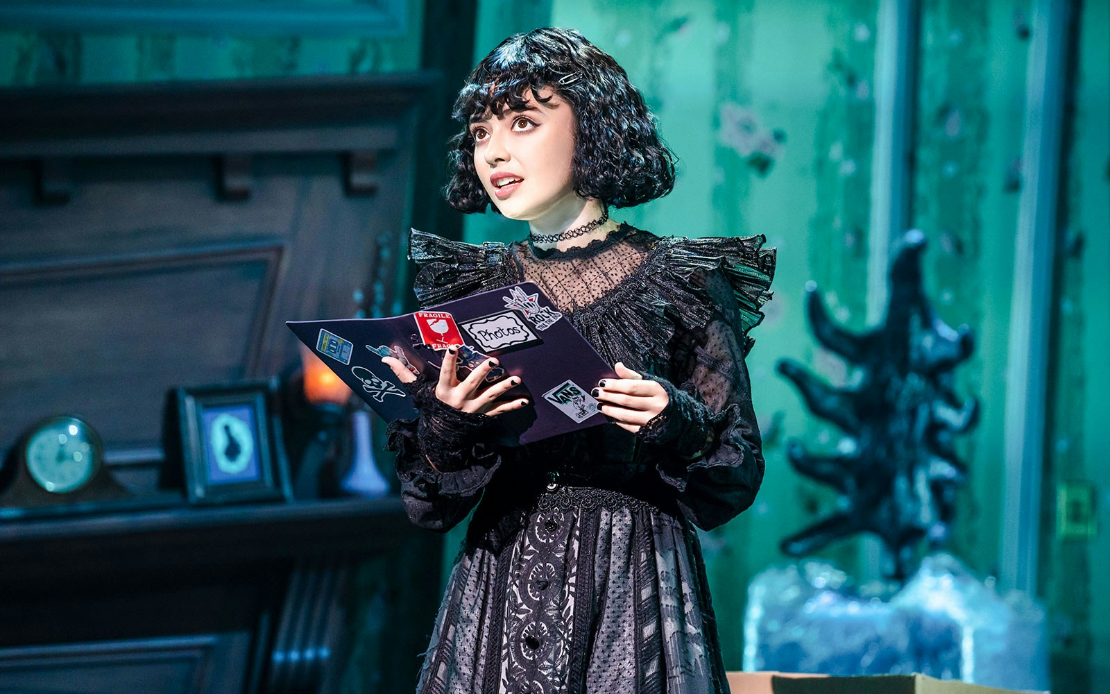 Performer on stage at Beetlejuice Broadway show holding a book.
