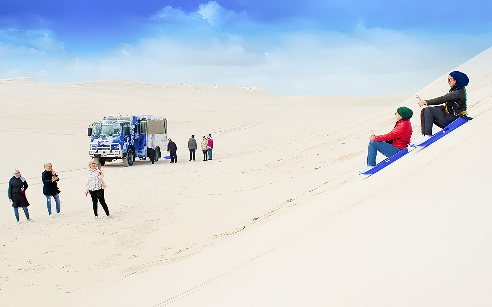People sandboarding on dunes with a 4WD vehicle in Lancelin, Australia.