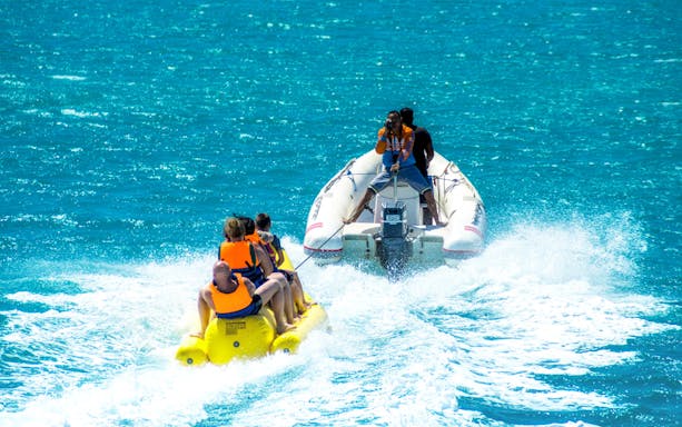 Banana boat ride on turquoise waters during Paradise Island snorkeling tour from Hurghada.