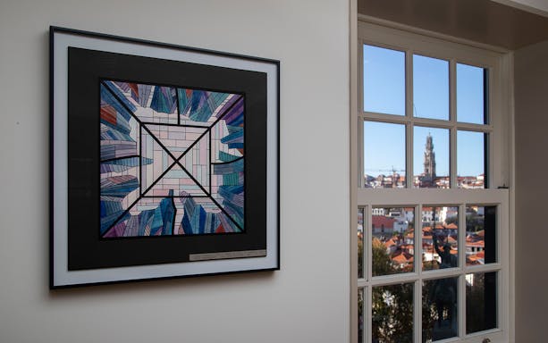 Stained glass artwork at Museu do Vitral in Porto with cityscape view through window.