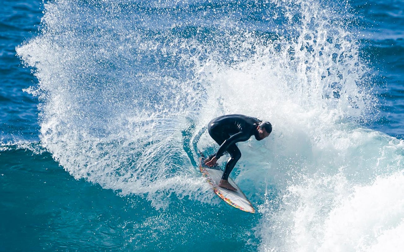 Surfer riding a wave in Madeira, Portugal.