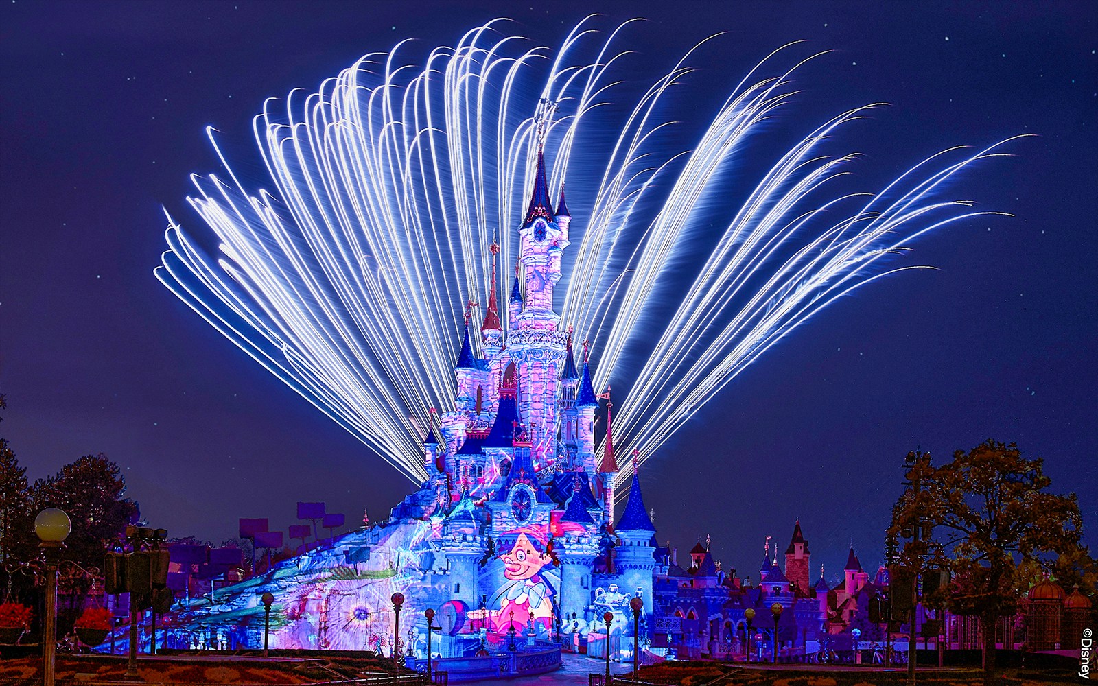 Fireworks display over Sleeping Beauty Castle during Disneyland Paris light show.
