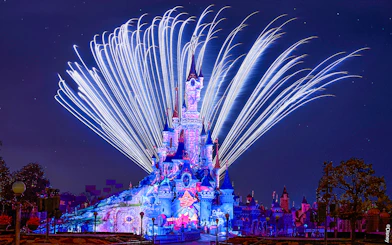 Fireworks display over Sleeping Beauty Castle during Disneyland Paris light show.