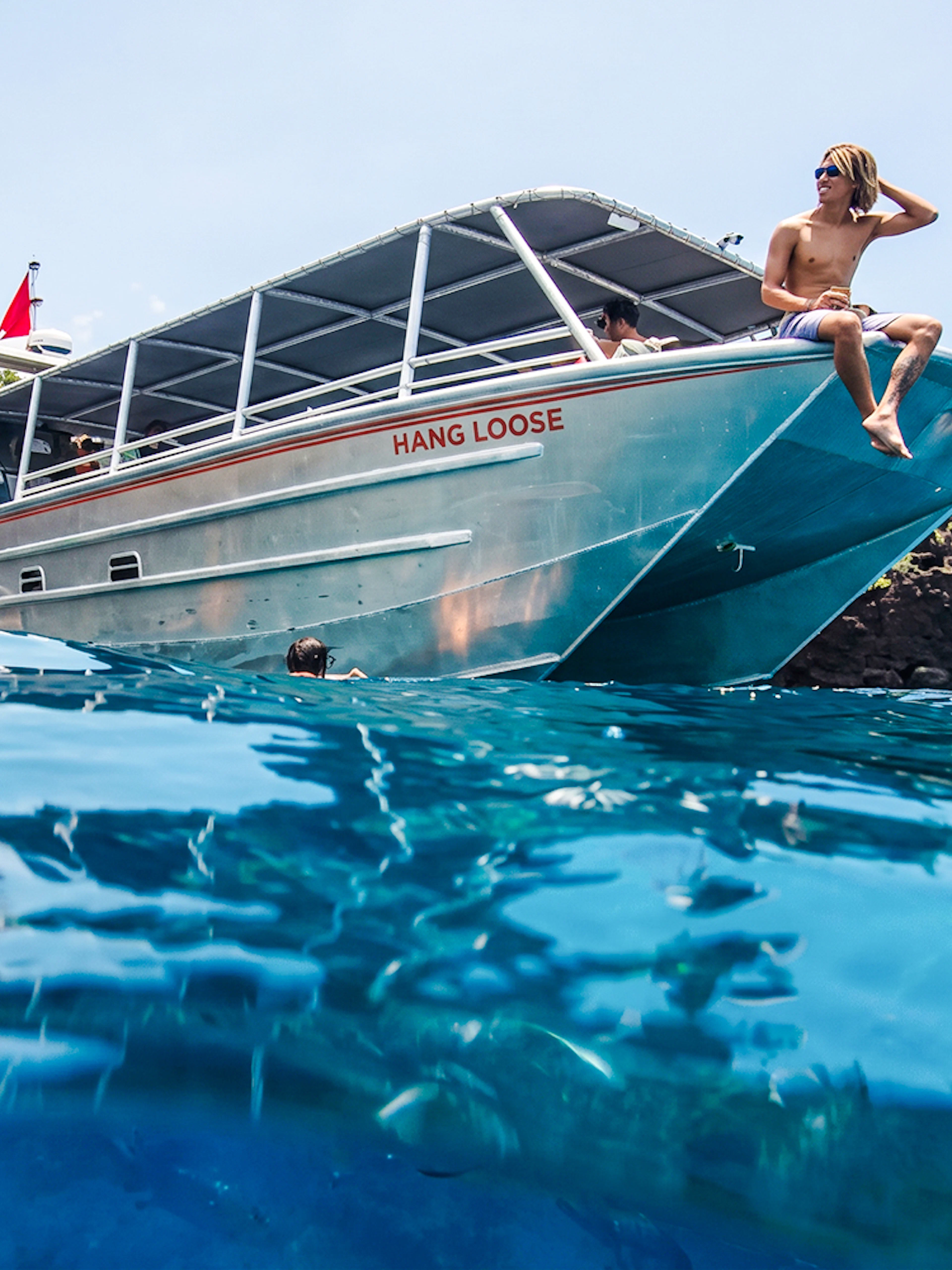 Catamaran anchored at Kealakekua Bay with snorkelers in the water.