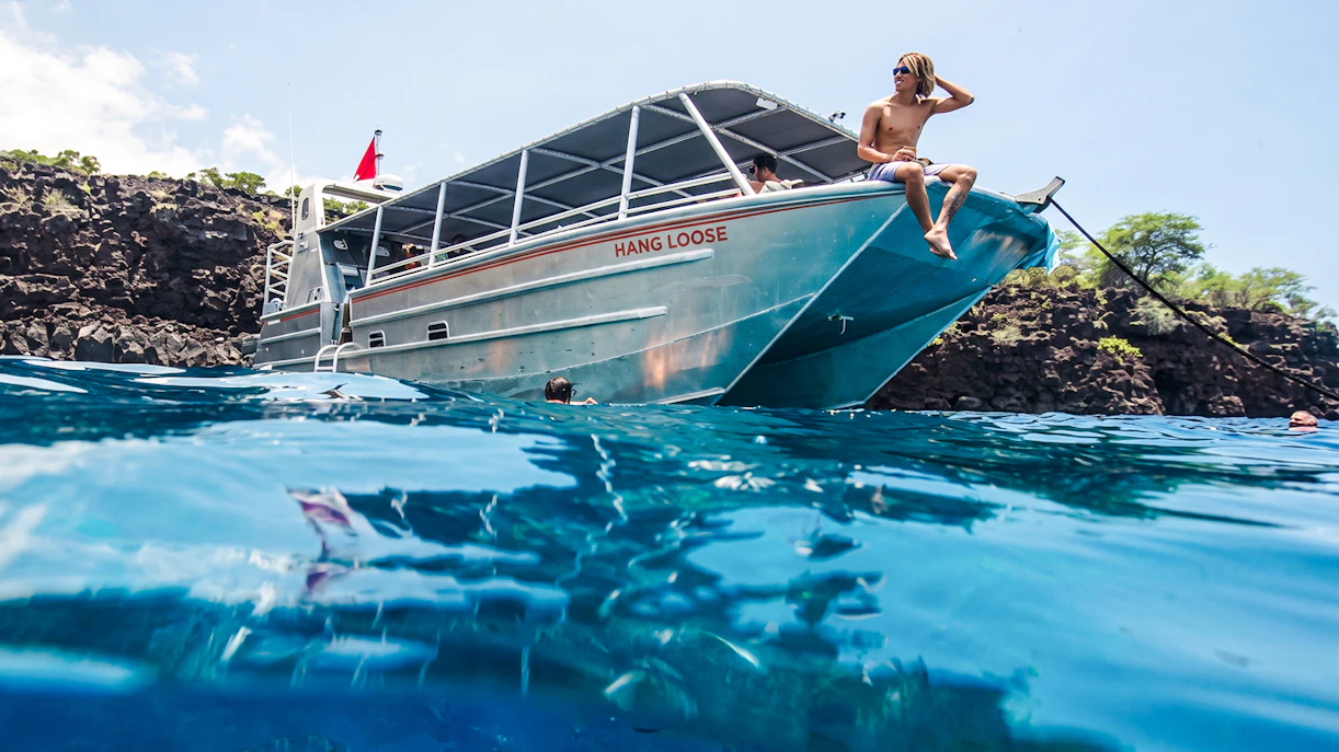 Catamaran anchored at Kealakekua Bay with snorkelers in the water.