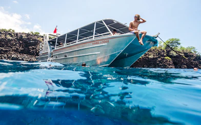 Catamaran anchored at Kealakekua Bay with snorkelers in the water.