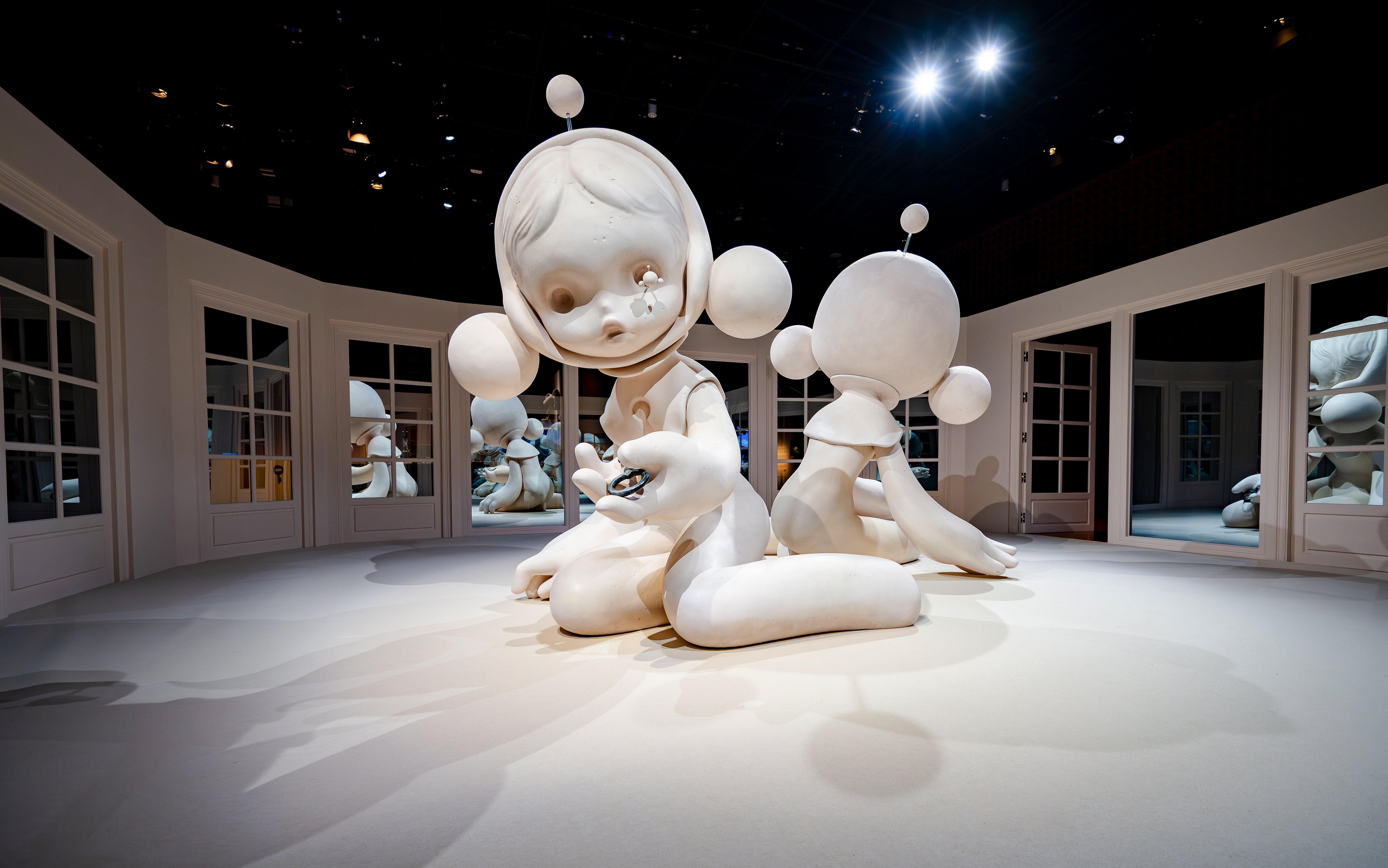Sculpture installation at National Museum of Singapore featuring large white figures in a mirrored room.