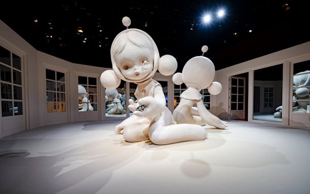 Sculpture installation at National Museum of Singapore featuring large white figures in a mirrored room.