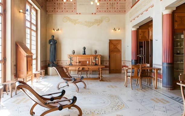 Villa Kerylos interior with Greek-style decor and wooden furniture in Beaulieu-sur-Mer, France.