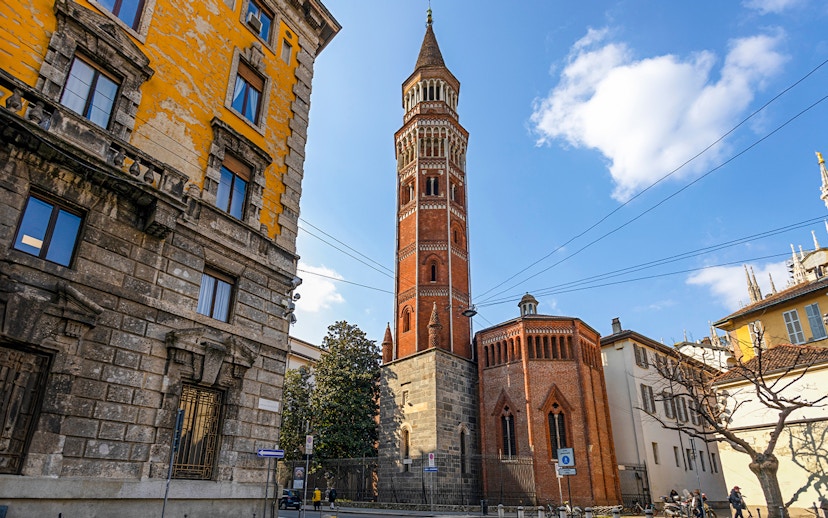 Church of St Gottardo's red brick tower in Milan with surrounding buildings.