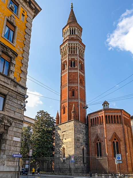 Church of St Gottardo's red brick tower in Milan with surrounding buildings.