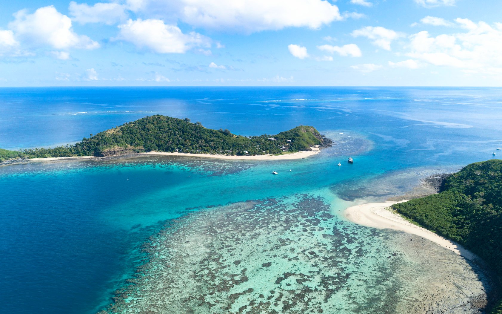 Aerial view of Manta Channel near Mantaray Island Resort, Fiji, showcasing clear blue waters and coral reefs.
