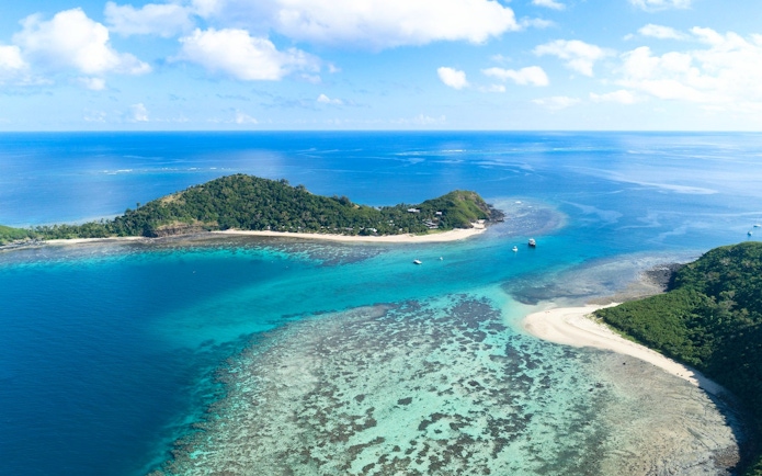 Aerial view of Manta Channel near Mantaray Island Resort, Fiji, showcasing clear blue waters and coral reefs.