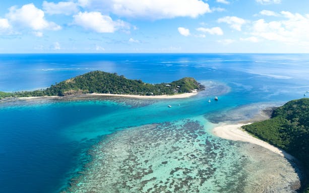 Aerial view of Manta Channel near Mantaray Island Resort, Fiji, showcasing clear blue waters and coral reefs.
