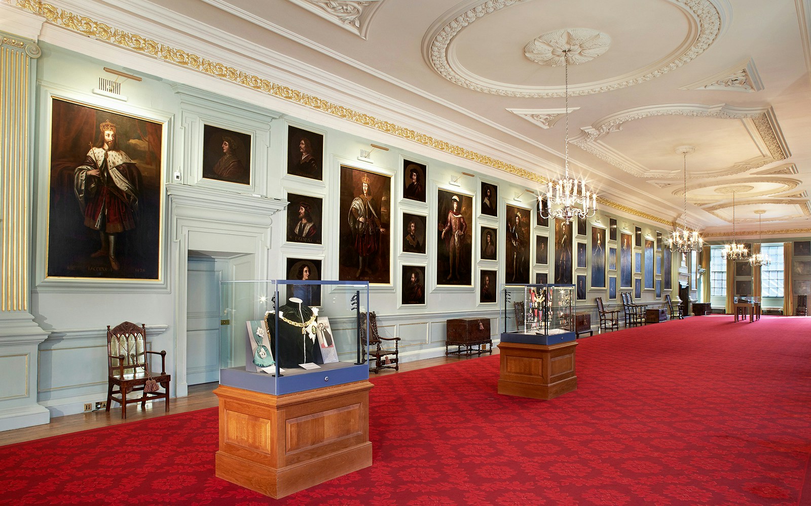 Visitors viewing portraits in the gallery of the Palace of Holyroodhouse, London.