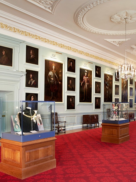 Visitors viewing portraits in the gallery of the Palace of Holyroodhouse, London.