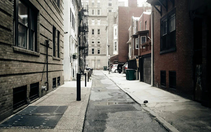 Narrow alleyway in Philadelphia with historic brick buildings, part of a self-guided city exploration game.