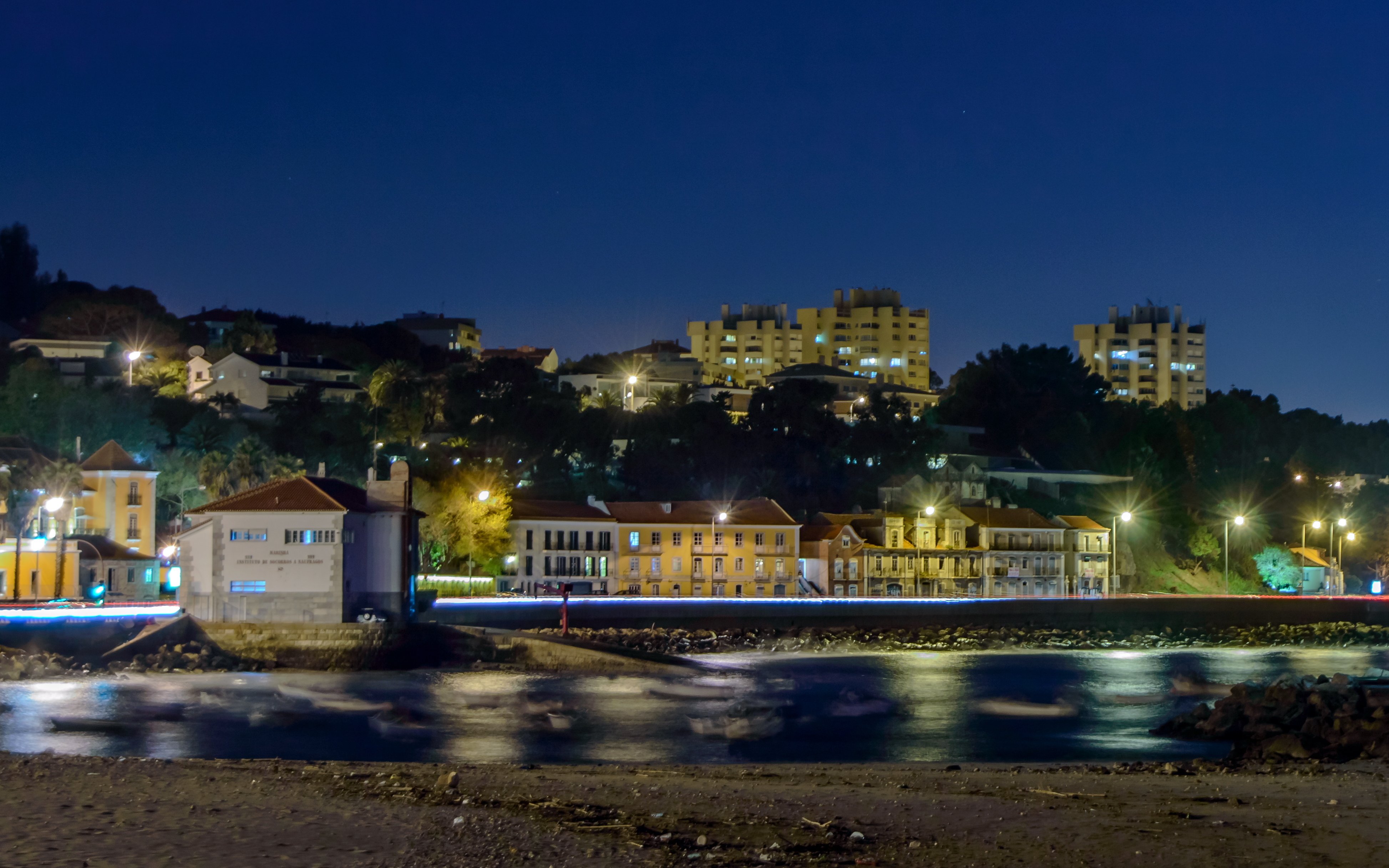 Panoramic night view of Paço de Arcos village waterfront in Portugal.