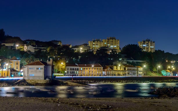 Panoramic night view of Paço de Arcos village waterfront in Portugal.