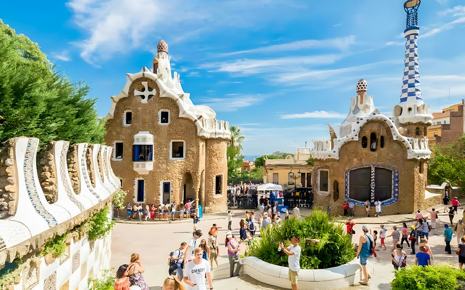 Colorful mosaic-covered buildings at Park Güell, Barcelona, showcasing Gaudí's unique architectural style.