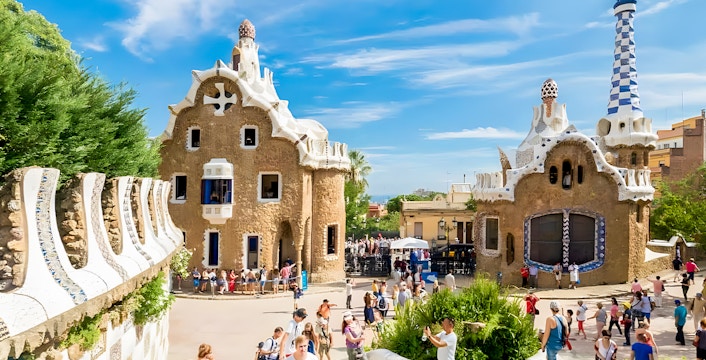 Colorful mosaic-covered buildings at Park Güell, Barcelona, showcasing Gaudí's unique architectural style.