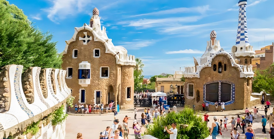 Colorful mosaic-covered buildings at Park Güell, Barcelona, showcasing Gaudí's unique architectural style.