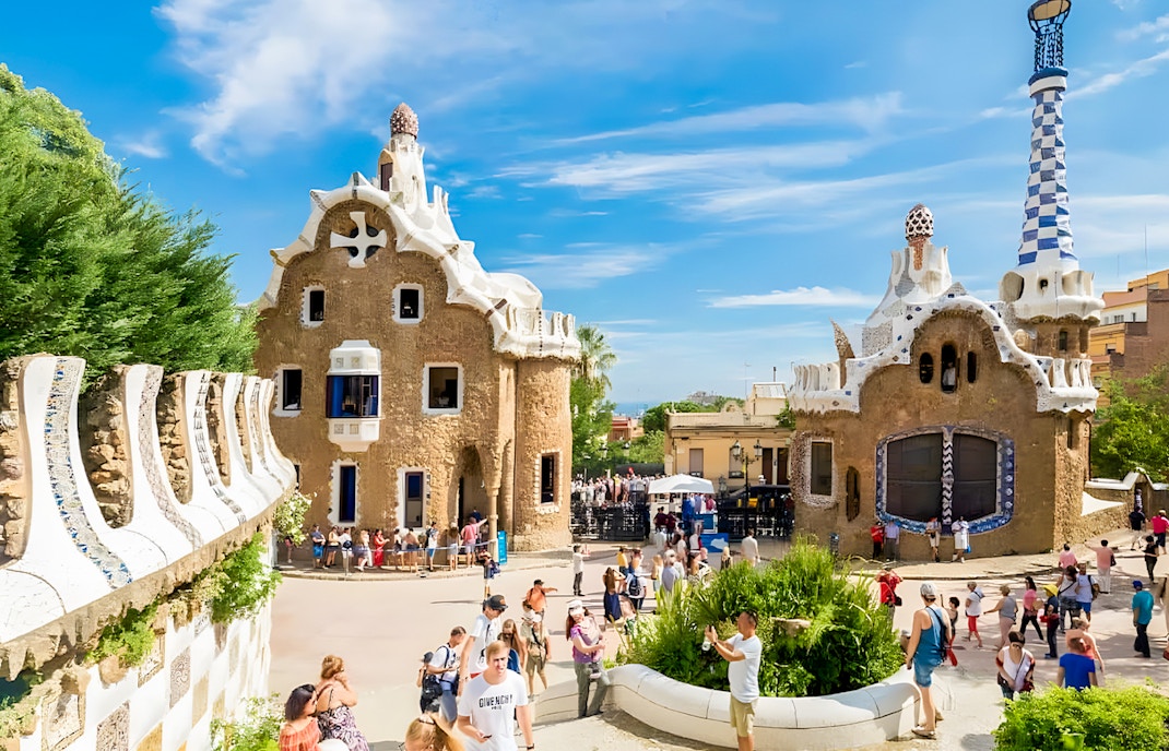 Colorful mosaic-covered buildings at Park Güell, Barcelona, showcasing Gaudí's unique architectural style.