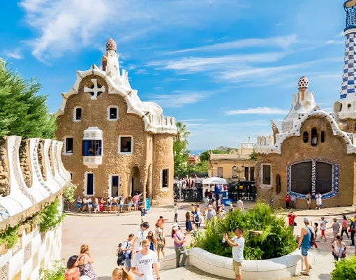 Colorful mosaic-covered buildings at Park Güell, Barcelona, showcasing Gaudí's unique architectural style.