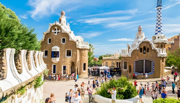 Colorful mosaic-covered buildings at Park Güell, Barcelona, showcasing Gaudí's unique architectural style.