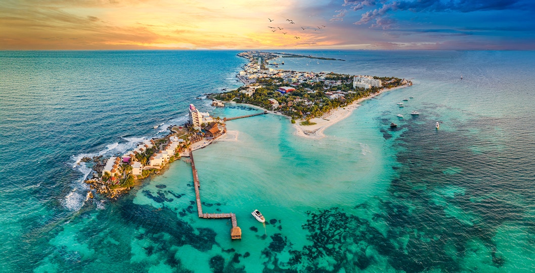 Aerial view of Isla Mujeres near Cancun, Mexico, with sunset over the ocean.