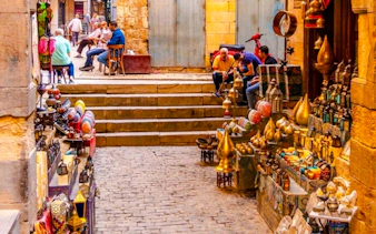 Market stalls with brass lamps and colorful goods in Khan el-Khalili, Cairo.