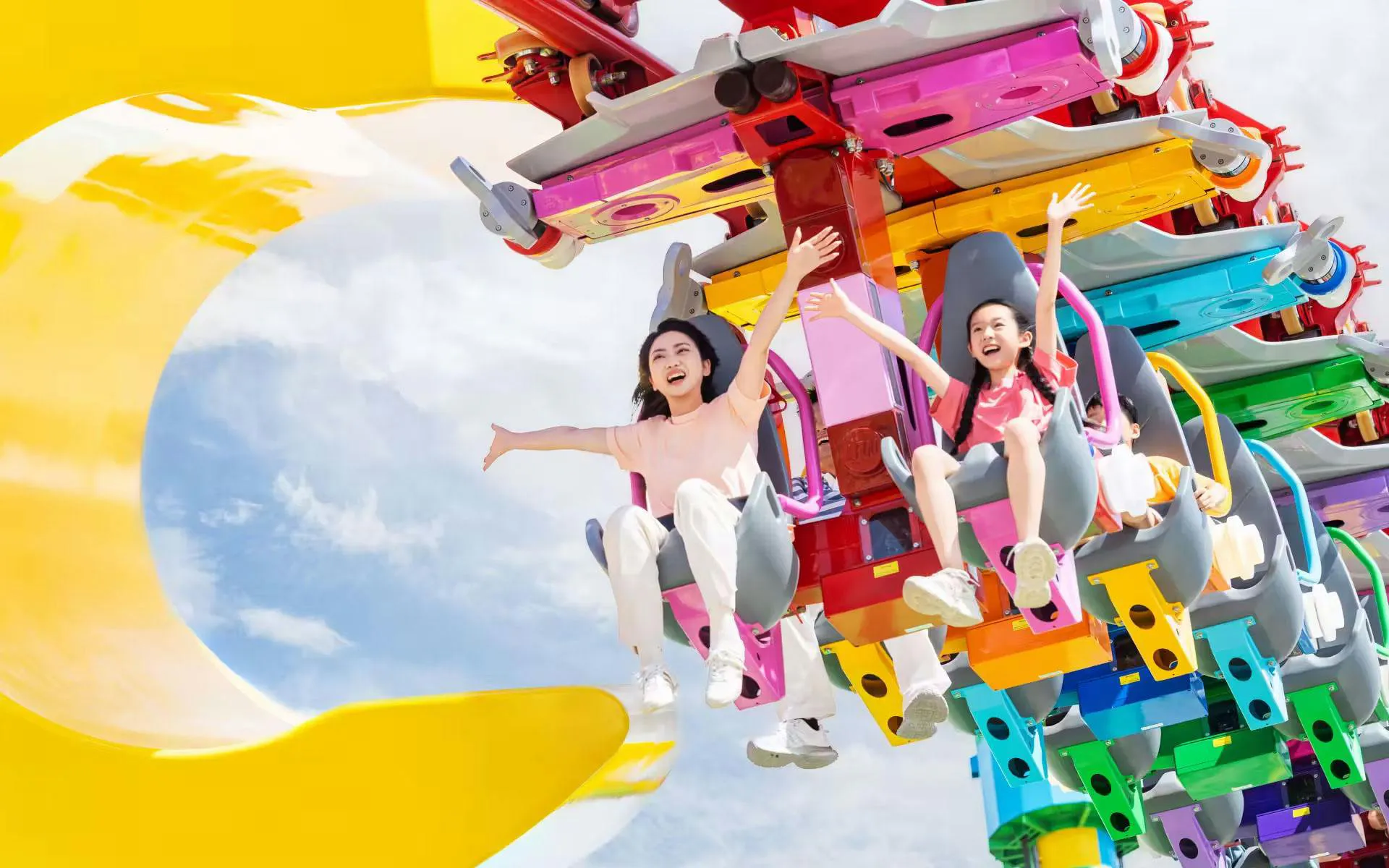 Family enjoying the colorful Big LEGO Coaster at the resort, featuring inverted roller coaster design.