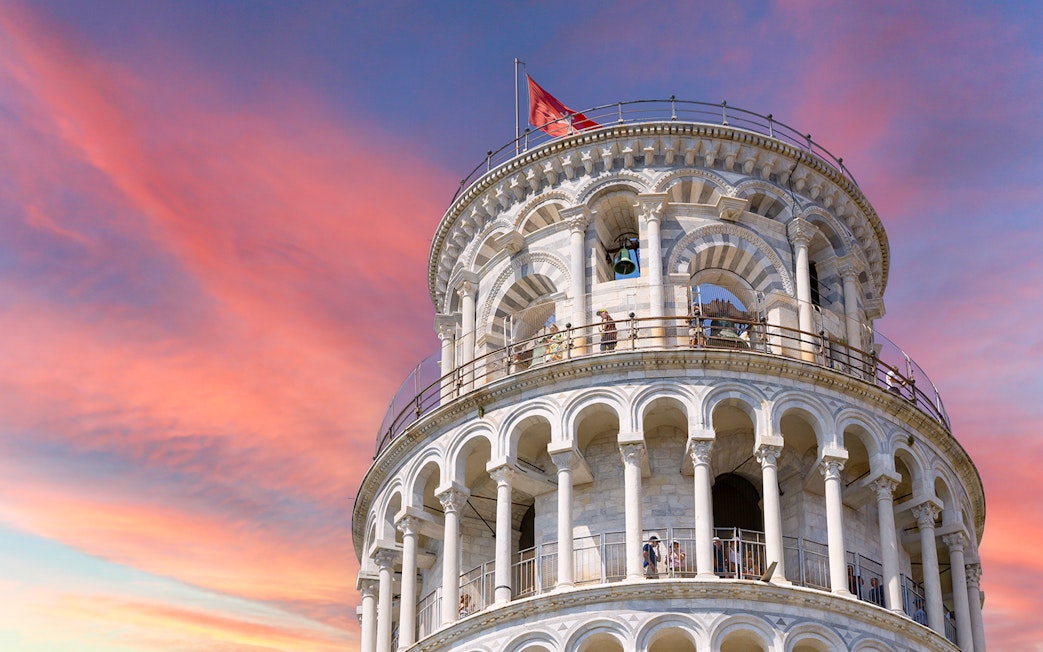 Leaning Tower of Pisa upper levels with sunset sky in Pisa, Italy.