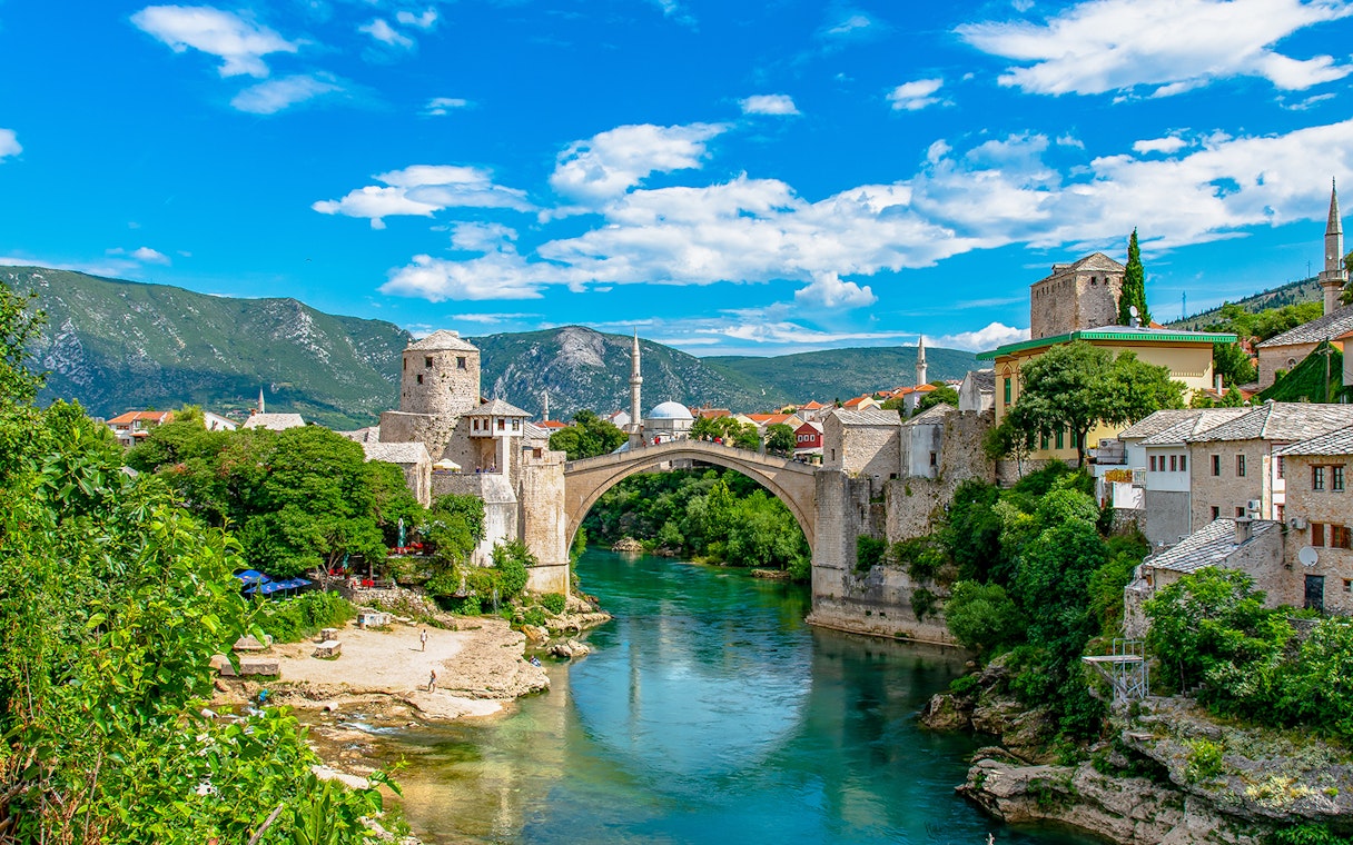 Stari Most bridge over Neretva River in Mostar, Bosnia and Herzegovina, with surrounding historic buildings.