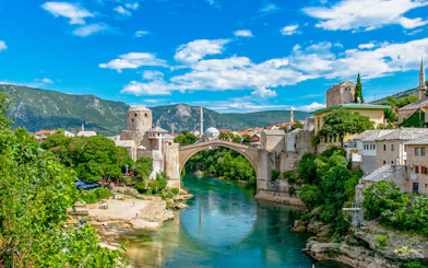 Stari Most bridge over Neretva River in Mostar, Bosnia and Herzegovina, with surrounding historic buildings.