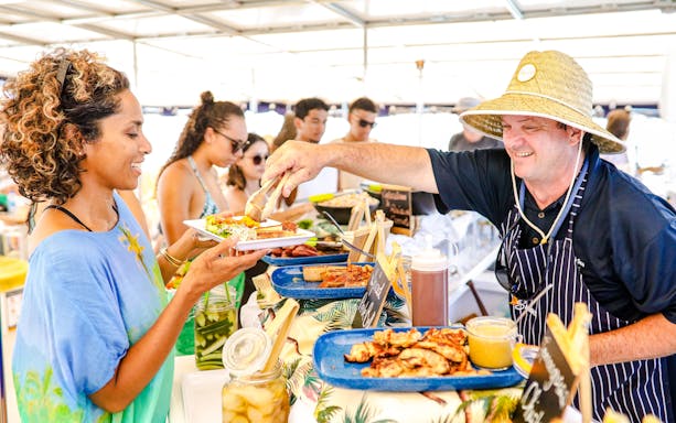 Staff serving food to guests on a catamaran, South Sea Sailing, Fiji.