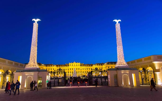 Schonbrunn Palace entrance lit up at night during the Christmas market in Vienna.