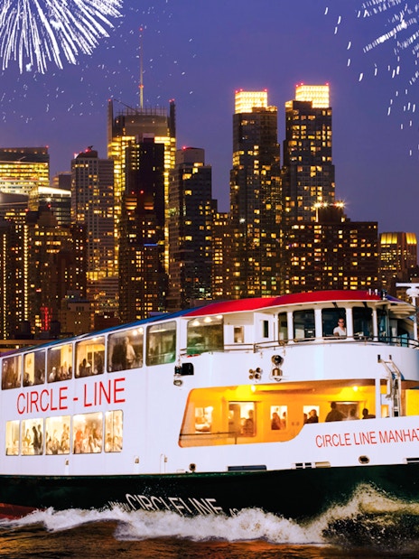 Cruise ship on New Year’s Eve in NYC with fireworks over Manhattan skyline.