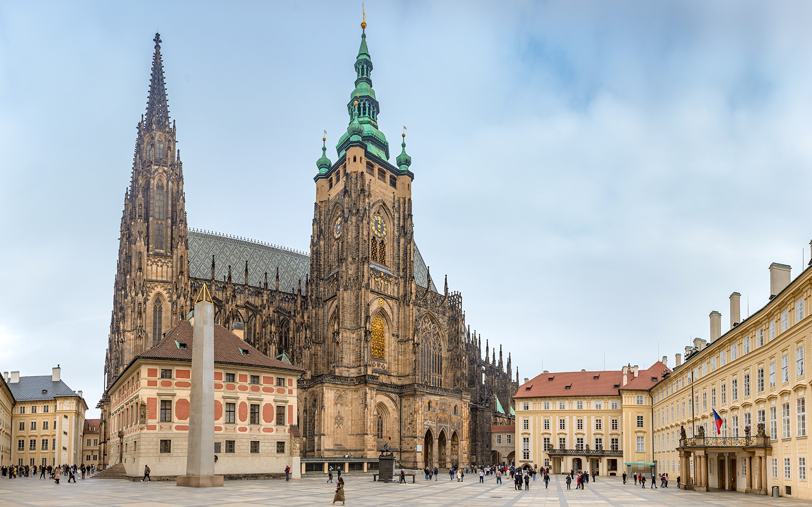 Prague Castle with tourists exploring the historic architecture and gardens.
