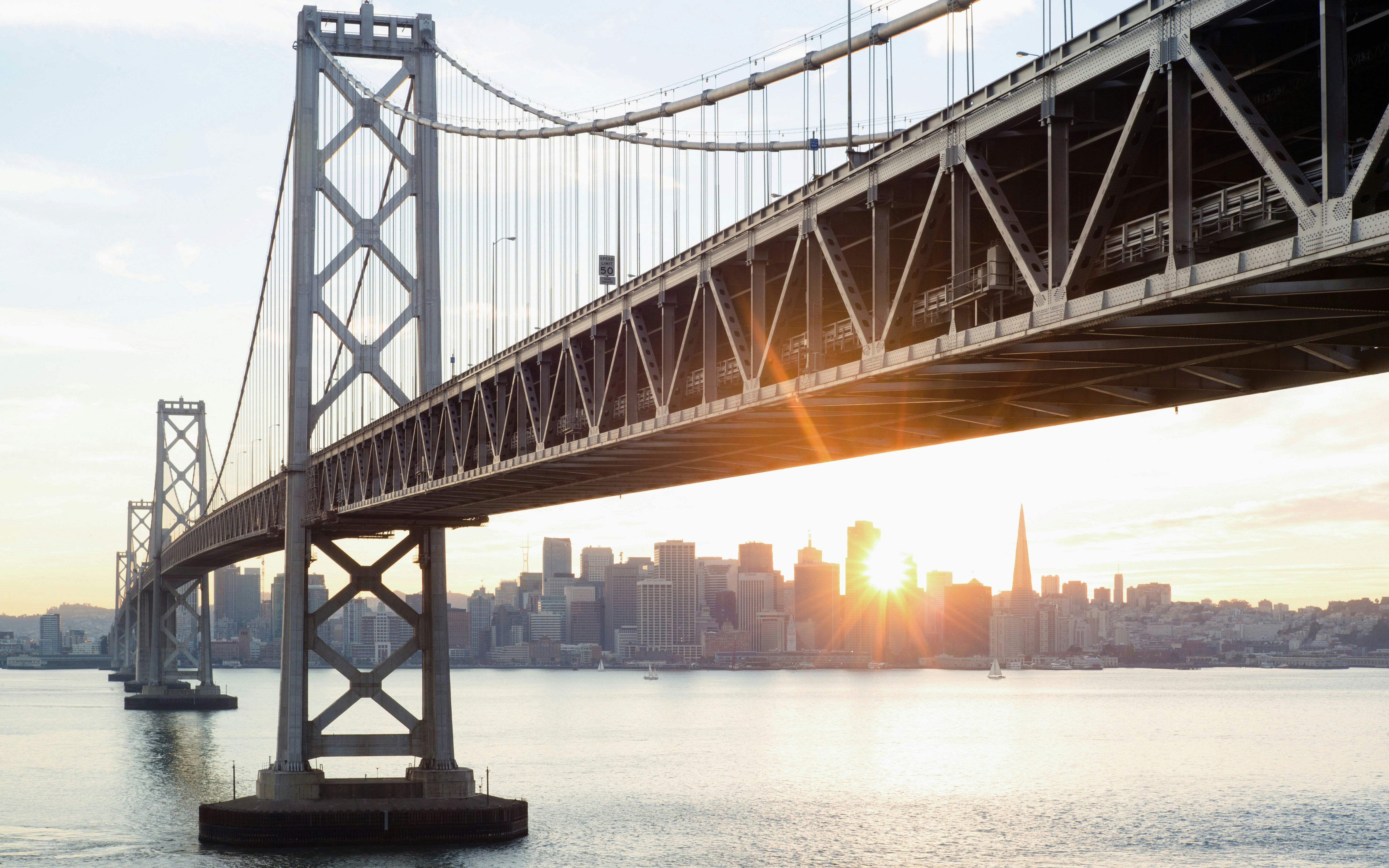 Oakland Bay Bridge with San Francisco skyline at sunrise.