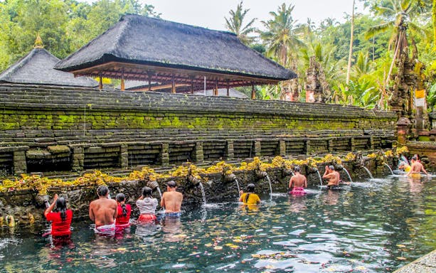Visitors at Tirta Empul Temple's holy spring, Ubud, Bali, during a purification ritual.