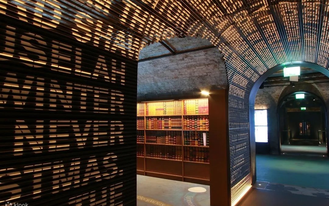 Dimly lit museum corridor with illuminated text wall and bookshelves, Epic Museum.