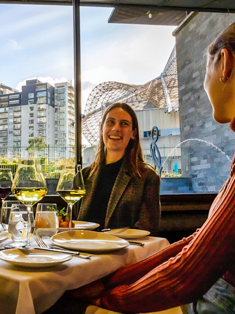 Tourists enjoying a three-course lunch at the National Gallery of Victoria with cityscape views.