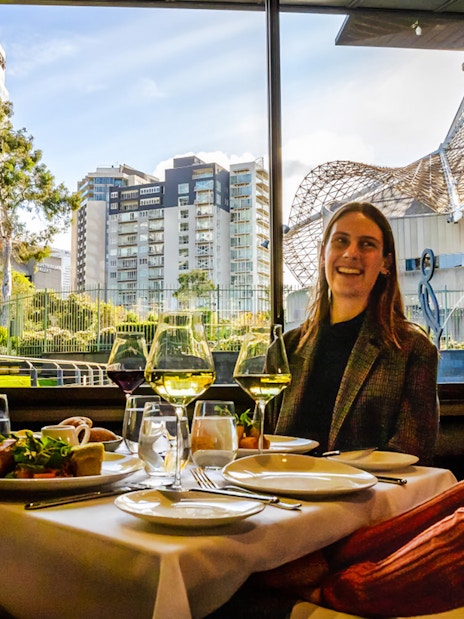 Tourists enjoying a three-course lunch at the National Gallery of Victoria with cityscape views.