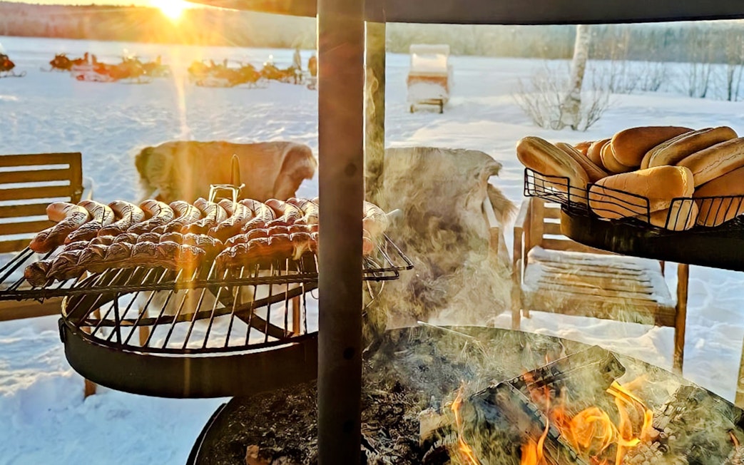 Barbeque with sausages and buns during Arctic Snowmobile Safari in Rovaniemi.