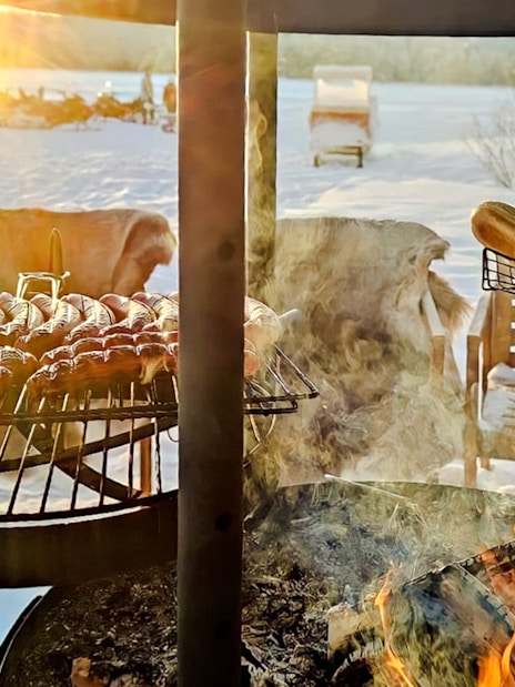 Barbeque with sausages and buns during Arctic Snowmobile Safari in Rovaniemi.