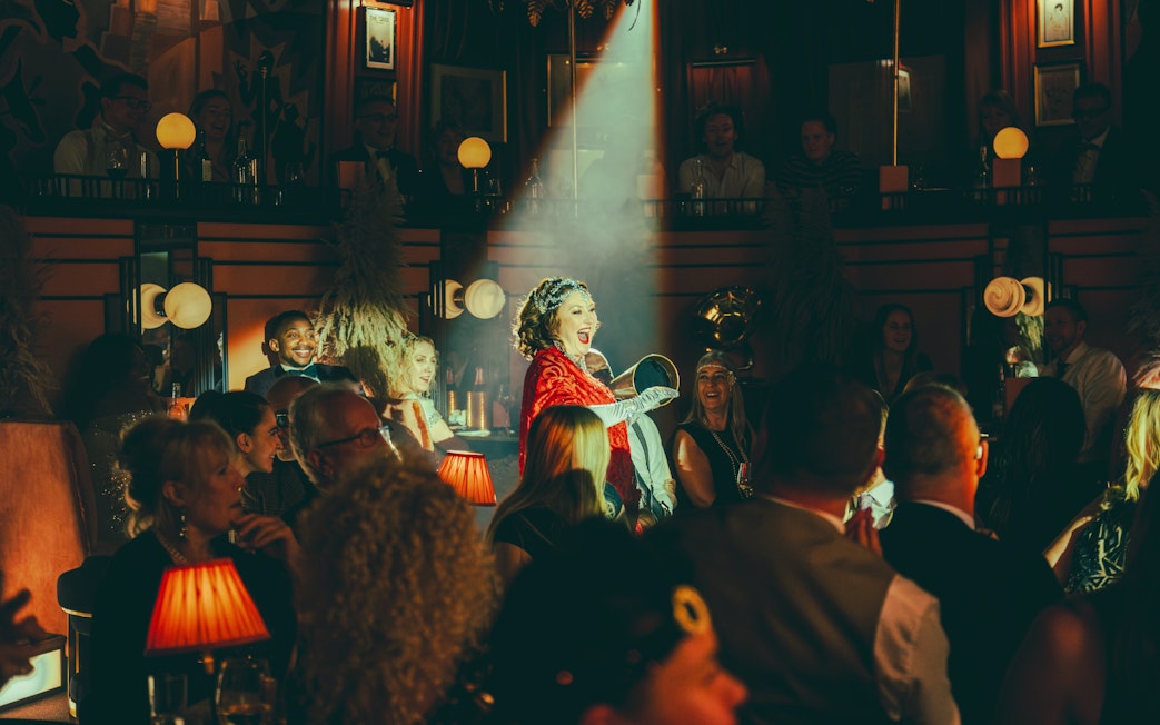 Performer entertaining audience at 58th Street venue with spotlight on stage.