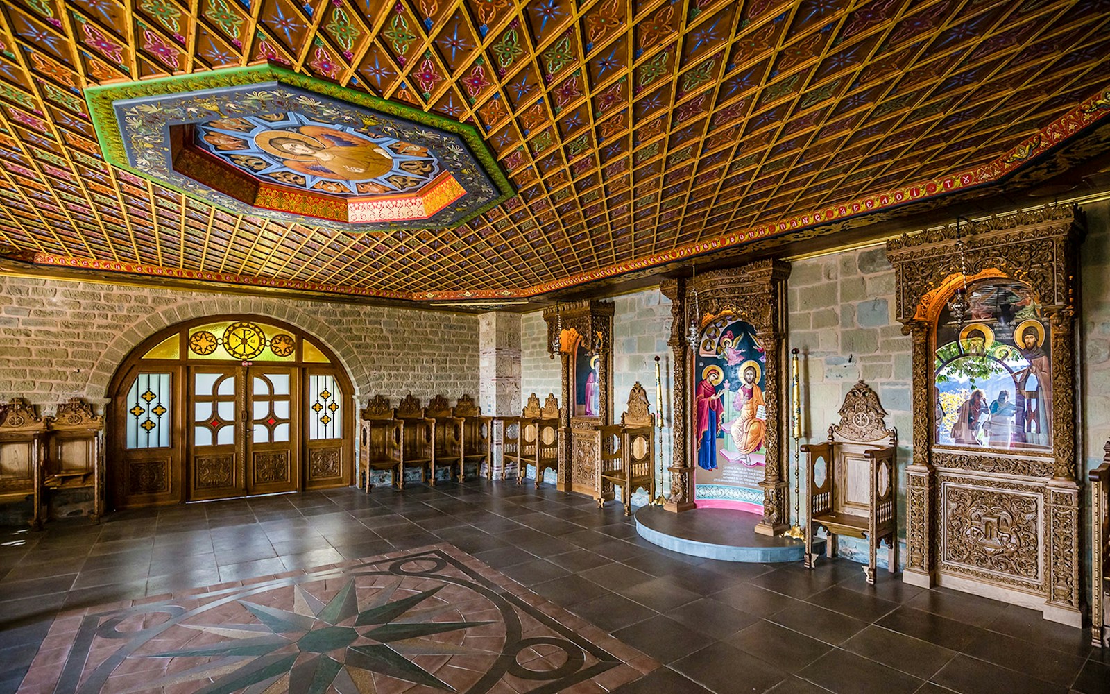 Monastery interior in Meteora with ornate wooden carvings and religious icons.